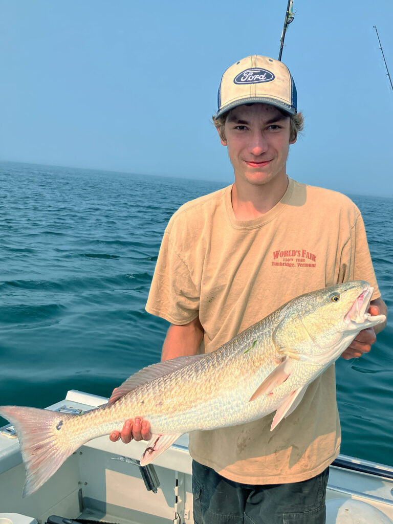 Smiling angler on a boat displays the rare redfish he caught on Aug. 15.