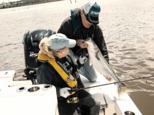 Anglers releasing a striper