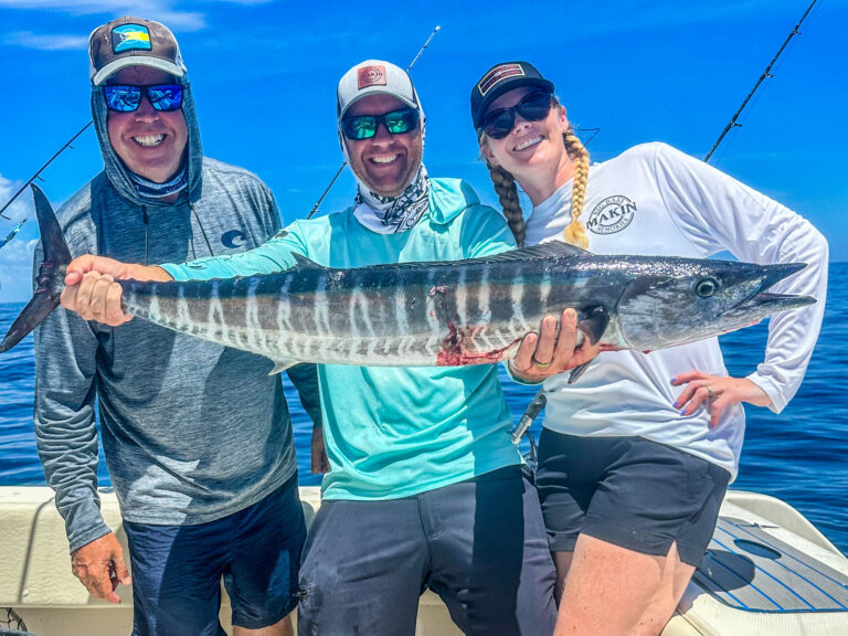 Three anglers display a Florida wahoo caught while jigging with electric reels.