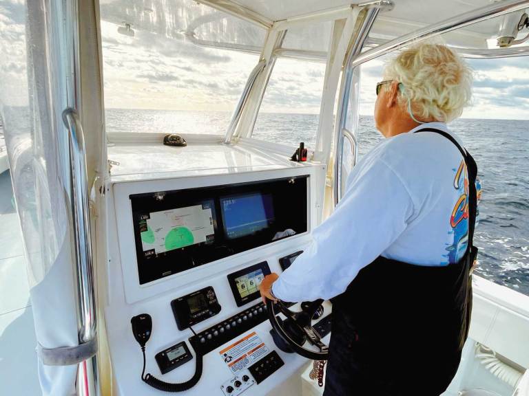 SWS1225-ELC-Fish-Tech-2 Angler at the helm watching fish finder screens